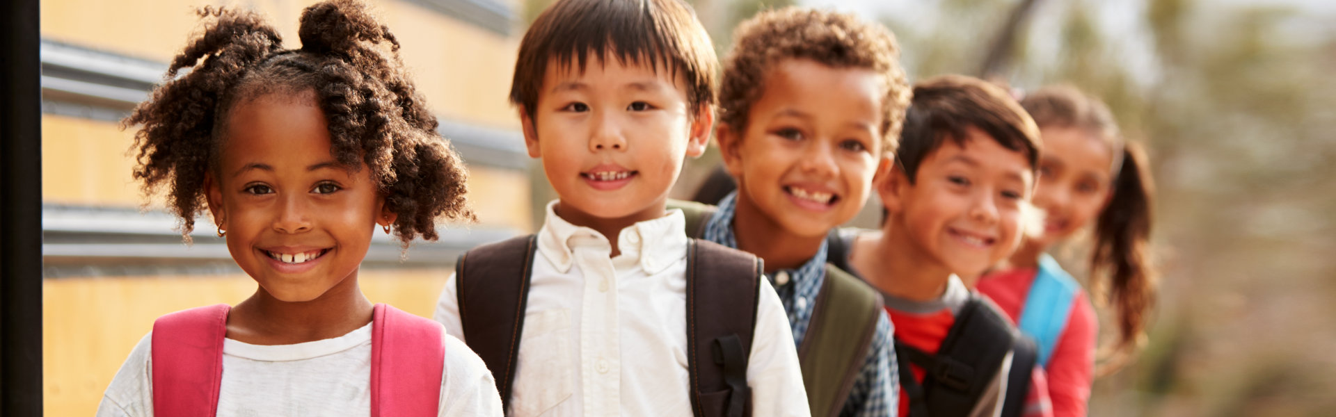 students outdoors waiting for the school bus